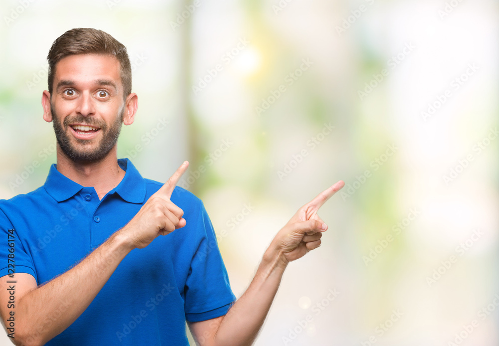Young handsome man over isolated background smiling and looking at the camera pointing with two hands and fingers to the side. Young handsome man over isolated background smiling and looking at the camera pointing with two hands and fingers to the side.