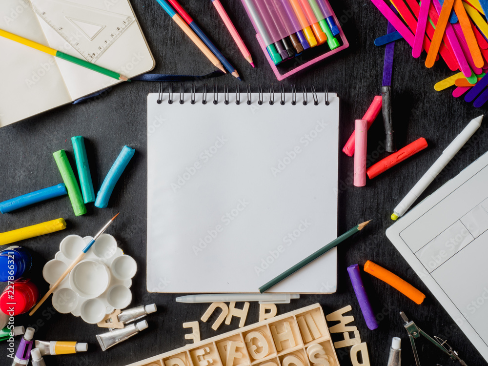 Back to school concept and artist kid concept with Drawing book, crayons, coloured pencils, Poster color and School stationery on wooden table background. Back to school concept and artist kid concept with Drawing book, crayons, coloured pencils, Poster color and School stationery on wooden table background.