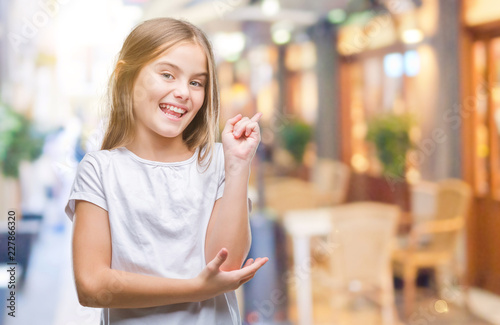 Young beautiful girl over isolated background with a big smile on face, pointing with hand and finger to the side looking at the camera.