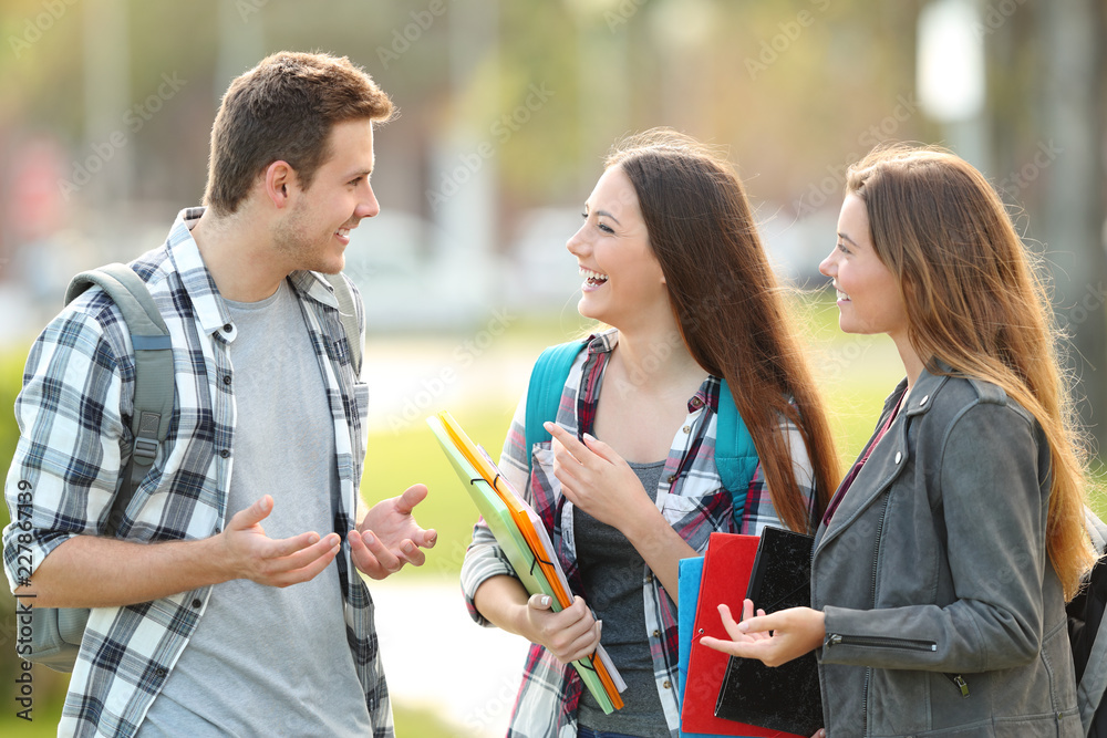 Three students are talking in the street Three students are talking in the street