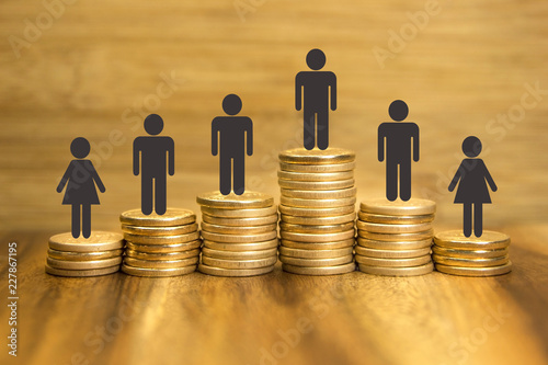 Income difference between men and women concept. Golden coins on wooden background. Gender pay discrimination.