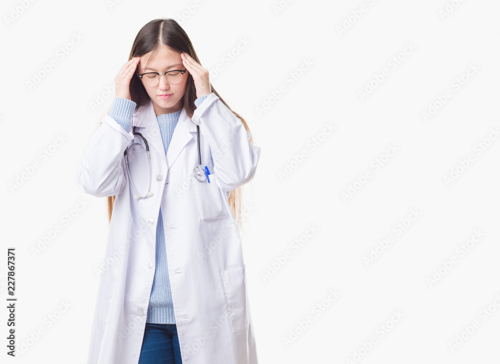 Young Chinese doctor woman over isolated background with hand on head for pain in head because stress. Suffering migraine. Young Chinese doctor woman over isolated background with hand on head for pain in head because stress. Suffering migraine.
