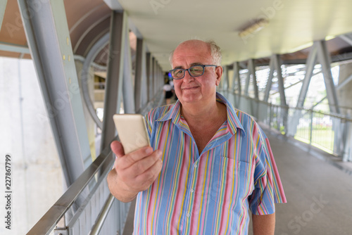 Overweight senior tourist man exploring around the city of Bangk photo