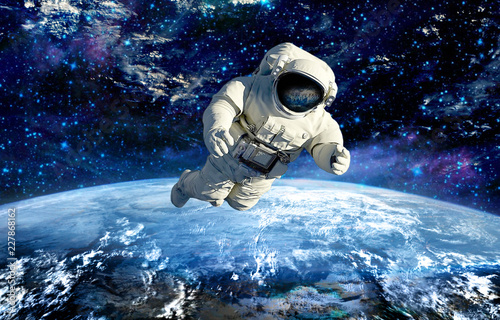 spaceman in outer space flying under a planet Earth.elements of this image furnished by NASA