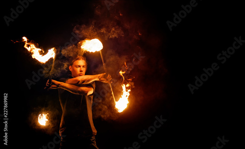 Fire show. Fire dancer dances with. Night performance. Dramatic portrait. Fire and smoke.