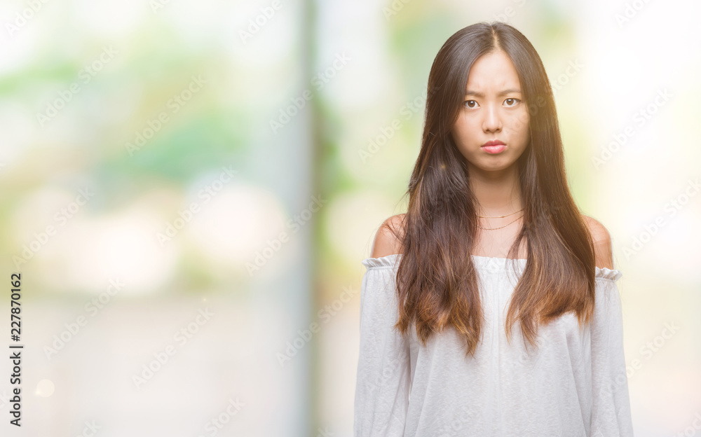 Young asian woman over isolated background skeptic and nervous, frowning upset because of problem. Negative person. Young asian woman over isolated background skeptic and nervous, frowning upset because of problem. Negative person.