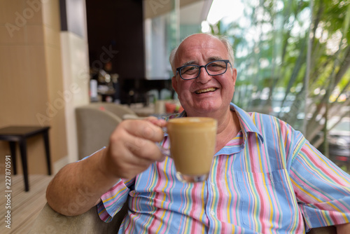 Overweight senior tourist man exploring around the city of Bangk photo