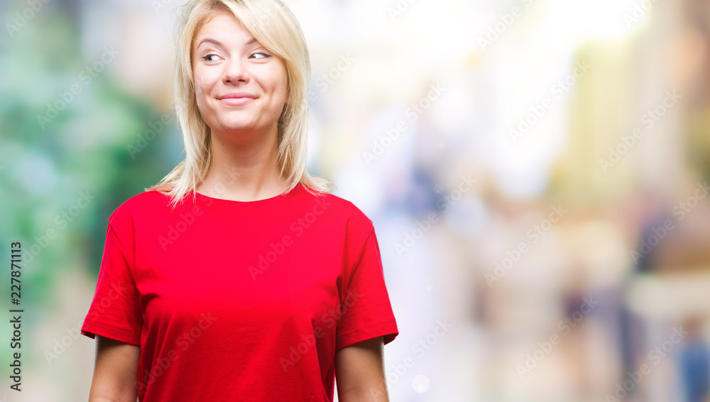 Young beautiful blonde woman wearing red t-shirt over isolated background smiling looking side and staring away thinking.