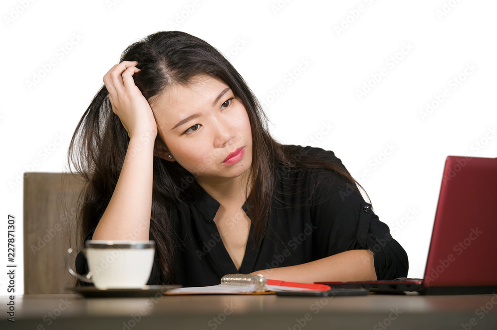 beautiful sad and depressed Asian Korean businesswoman working in stress at office computer desk feeling overwhelmed and frustrated suffering headache and depression