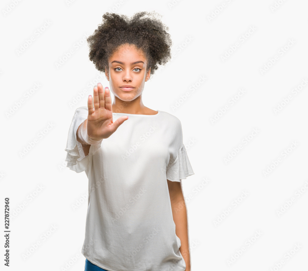 Young afro american woman over isolated background doing stop sing with palm of the hand. Warning expression with negative and serious gesture on the face. Young afro american woman over isolated background doing stop sing with palm of the hand. Warning expression with negative and serious gesture on the face.