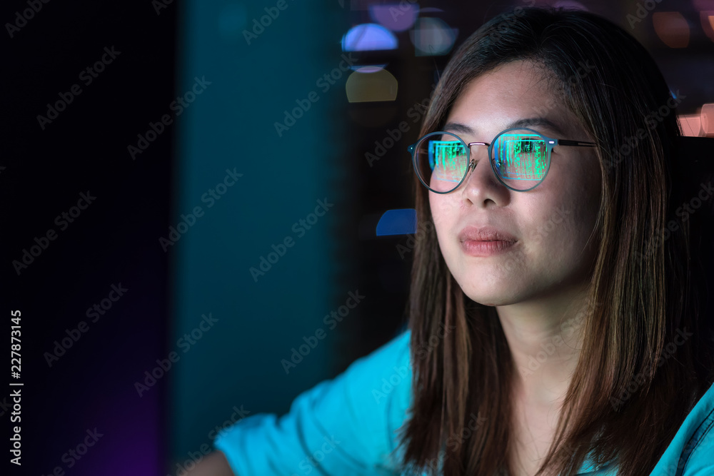 Closeup Asian Businesswoman working hard and looking the digital graphic on the table with front of computer desktop in workplace at late with serious action, Work hard and too late concept