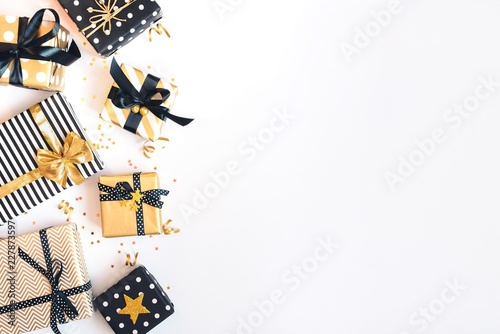 Top view of gift boxes in various black, white and golden designs. Flat lay, copy space. A concept of Christmas, New Year, birthday celebration event.