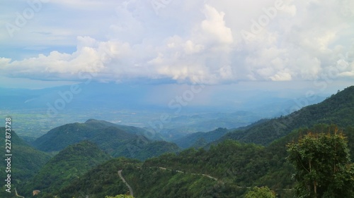 Beautiful landscape view of road on the mountains with clouds and rain in the countryside of Thailand.  © Aungsumol