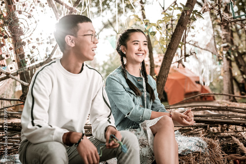 Asian couple. Pleased brunette female keeping smile on her face while enjoying nature