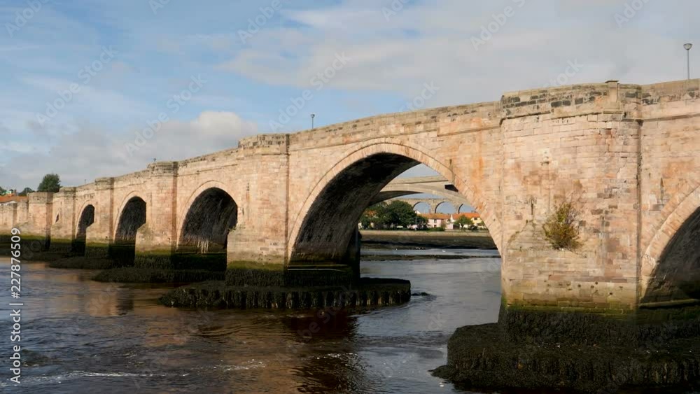 Zoom in-Arch on Berwick bridge over the River Tweed showing two additional bridges upstream, Royal Tweed bridge and Royal Borders bridge at the town of Berwick-Upon-Tweed, Northumberland, England. Zoom in-Arch on Berwick bridge over the River Tweed showing two additional bridges upstream, Royal Tweed bridge and Royal Borders bridge at the town of Berwick-Upon-Tweed, Northumberland, England.