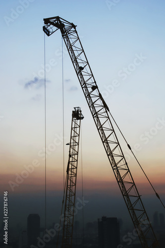 Construction Site with Tower Cranes and City Skyline at Twilight