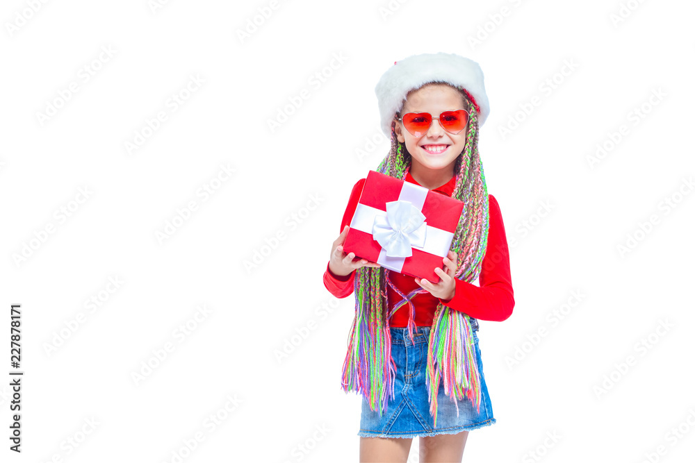 Girl in Santa's hat. Portrait of little cute girl holding box of Christmas present, Small girl hug her gift with happy and fun expression isolated on white background. Holiday gift Girl in Santa's hat. Portrait of little cute girl holding box of Christmas present, Small girl hug her gift with happy and fun expression isolated on white background. Holiday gift