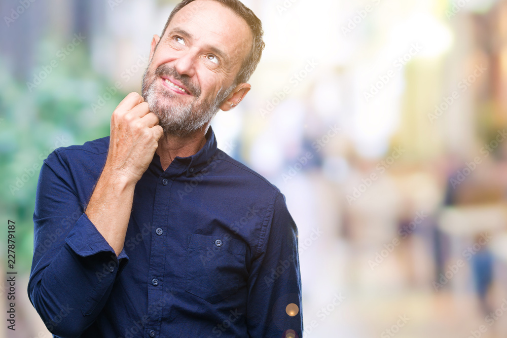 Naklejka premium Middle age hoary senior man over isolated background with hand on chin thinking about question, pensive expression. Smiling with thoughtful face. Doubt concept.
