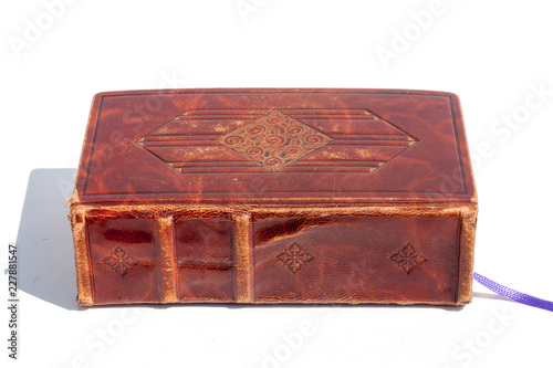 Antique book in a shiny brown leather cover with an embossed gold-plated motif