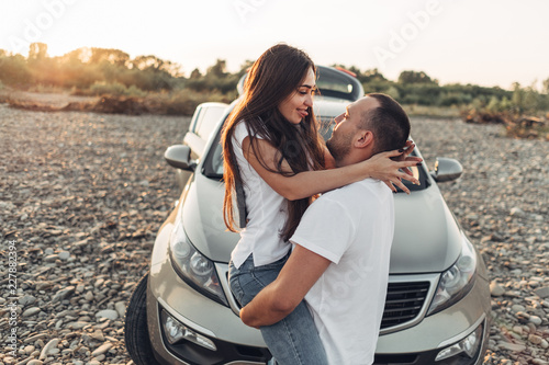 Happy Couple on Roadtrip into the Sunset in SUV Car