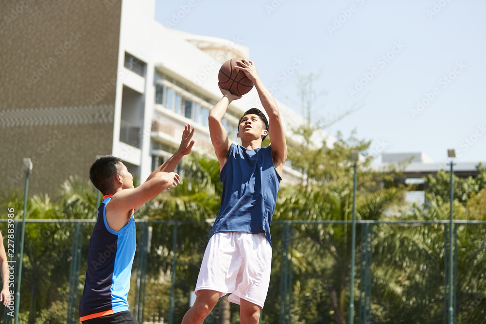 Naklejka premium young asiian men playing basketball