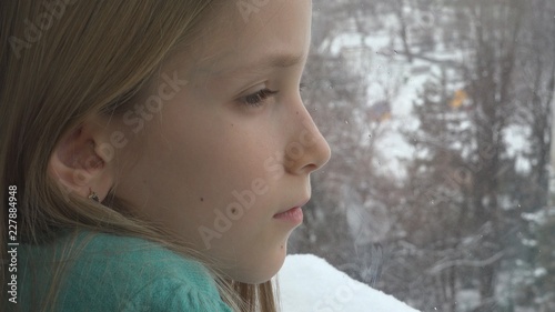 Sad Child Looking on Window  Unhappy Thoughtful Kid  Girl Face  Snowing Winter
