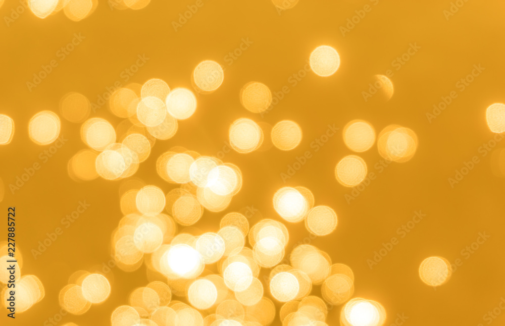 Obraz premium Yellow bokeh background texture. Golden blurred bright glare of light texture