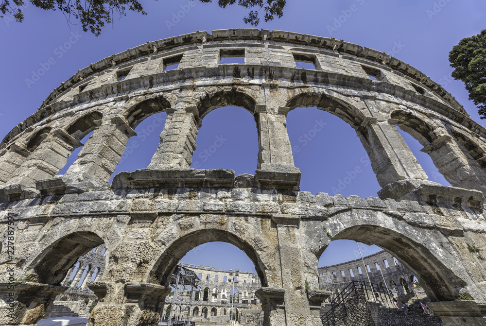 Interiors of the Roman amphitheater in Pula seen througs arches, Croatia