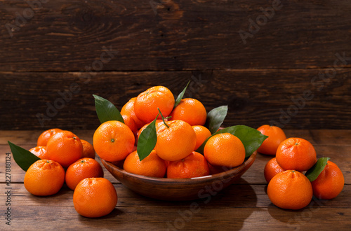 Fresh mandarin oranges fruit or tangerines with leaves in a bowl