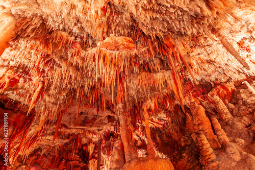 Huge limestone cave ceiling with stalactites hanging down photo