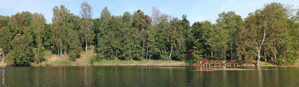 A typical rural Lithuanian landscape is a cold lake coast, birch forest and a wooden bath and pier on the shore A typical rural Lithuanian landscape is a cold lake coast, birch forest and a wooden bath and pier on the shore