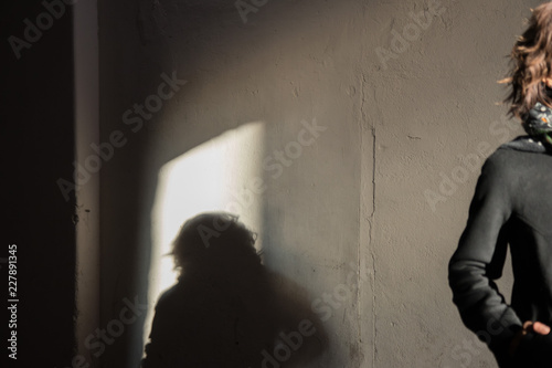 The black shadow on the white wall of young lady