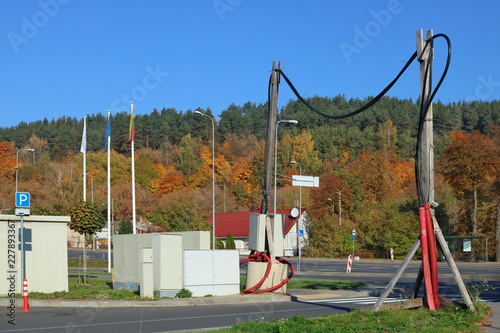 The cable of high-voltage electric power transmission line is fixed on wooden poles above the road. photo