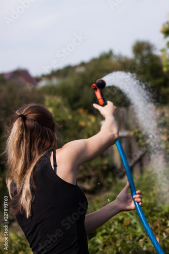 Woman watering the garden with a watering can,