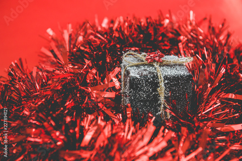 a christmas gift with snow in a red tinsel
