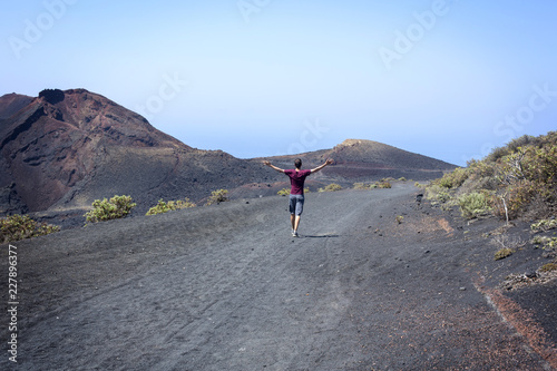 man walked between volcanoes with open arms photo