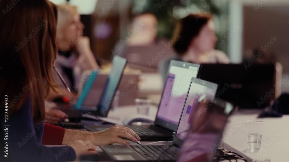 Group of people working on laptops. Hands of students typing with computer in class