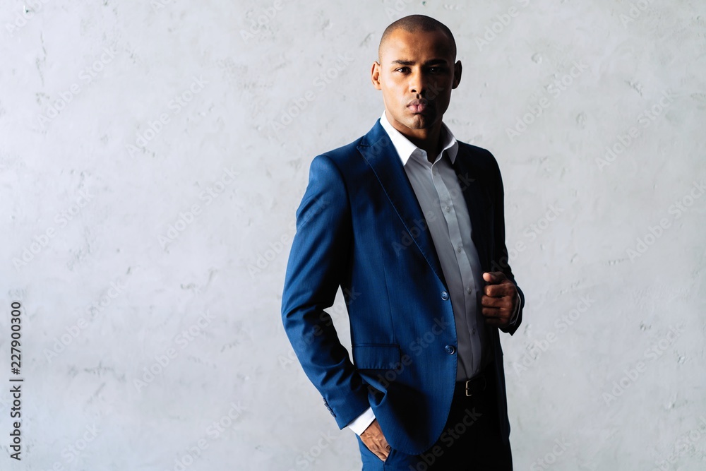 Cool african businessman standing on grey background. Cool african businessman standing on grey background.