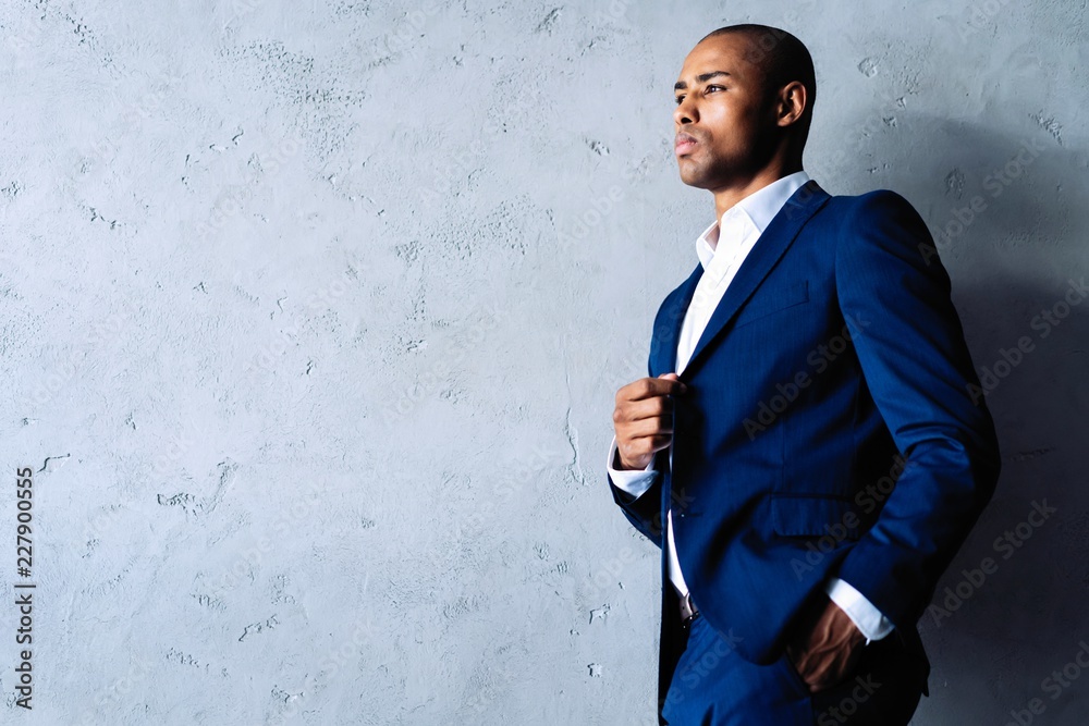 Cool african businessman standing on grey background. Cool african businessman standing on grey background.