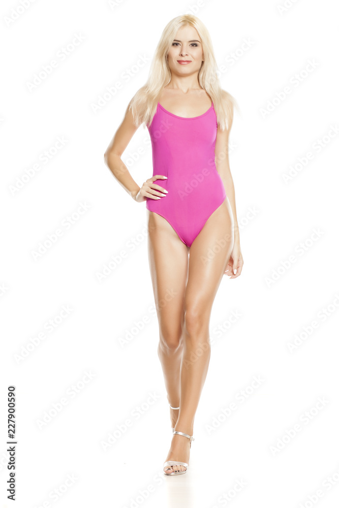 young pretty blonde woman walking in pink sweamsuit on white background young pretty blonde woman walking in pink sweamsuit on white background