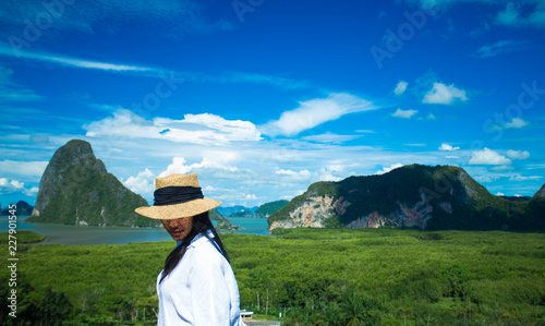 Happy young traveler woman enjoying a beautiful of nature at mountain panorama view point and sea Koh Samed Nang Chee,Phang Nga,Thailand