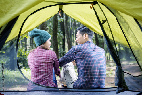 Rear view of asian couple relaxing outside the tent