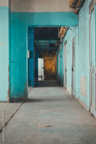 Corridor going into the distance, blue weathered walls.