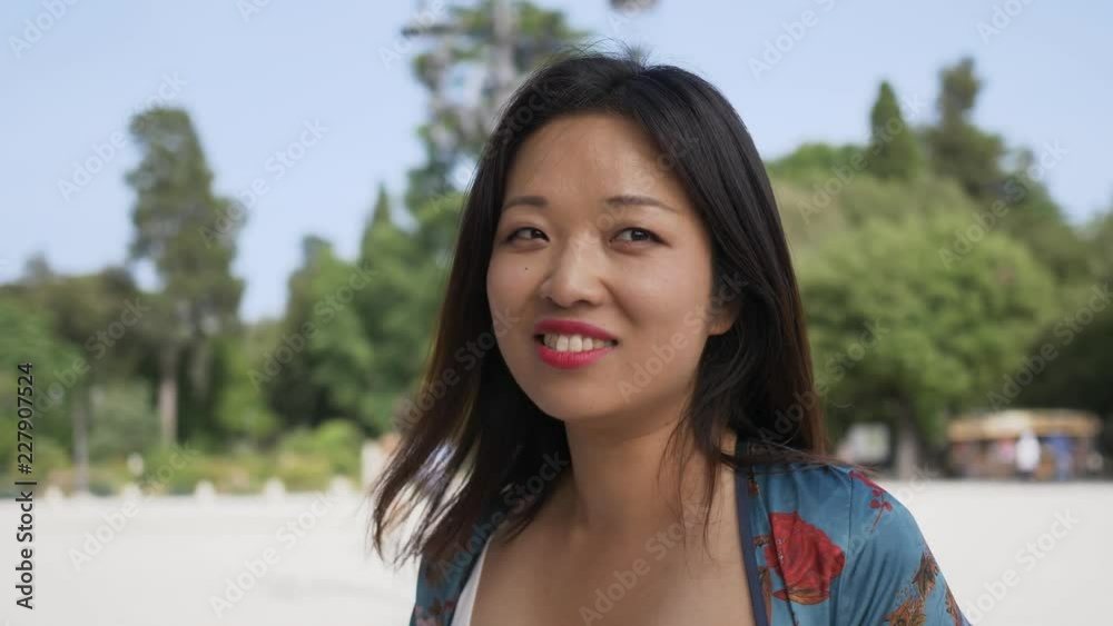 Funny happy pretty asian woman playing with camera- outdoor Funny happy pretty asian woman playing with camera- outdoor