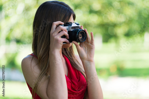 Smiling young woman using a camera © Minerva Studio