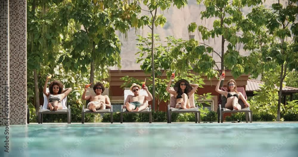 Group of five friends laying on chaise lounges, relaxing and drinking cocktails - vacation, lounge 4k