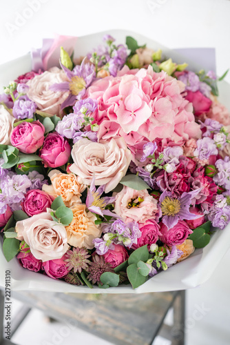 beautiful spring bouquet. flowers arrangement with various of colors in glass vase on old table. bright room  white wall. copy space