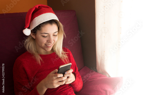 Happy teenage girl with the phone at Christmas photo