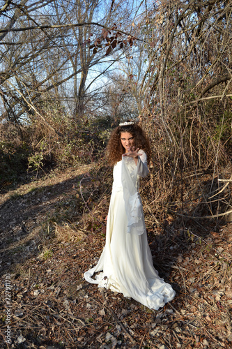 Lonely lady in white in the dark forest