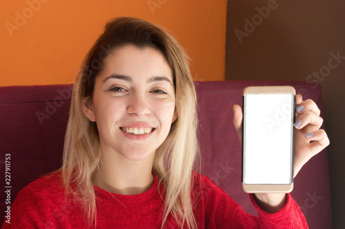 Girl showing a blank screen of the smartphone to the camera photo